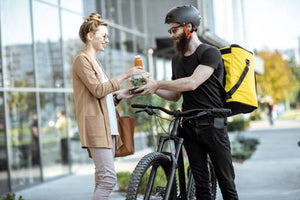 Delivery Guy on an ebike handing over the merchandize to the customer